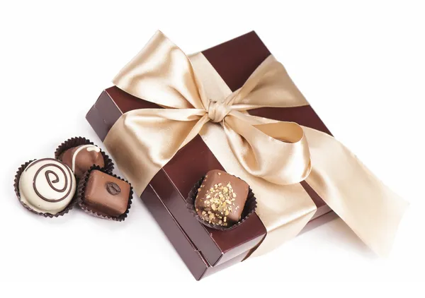 Brown box with candies and golden tape — Stock Photo, Image