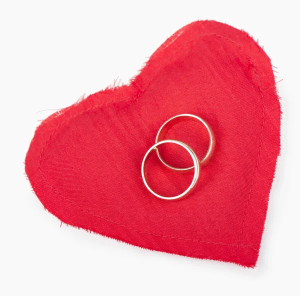 Big red heart from the fabric, two gold wedding rings — Stock Photo, Image