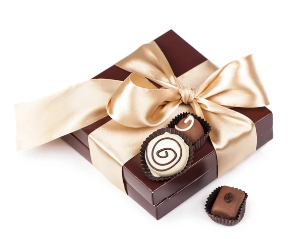 Bruine doos met snoepjes en gouden tape — Stockfoto