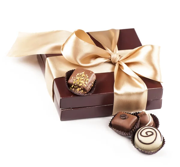 Brown box with candies and golden tape — Stock Photo, Image