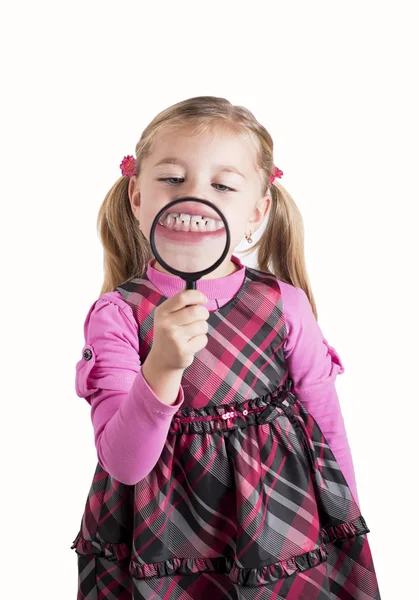 Funny girl showing teeth through a magnifying glass — Stock Photo, Image