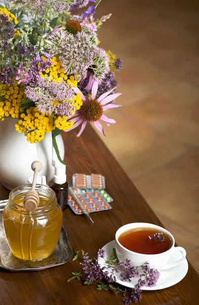 Bodegón de hierbas medicinales, miel, té de hierbas y medicinas —  Fotos de Stock