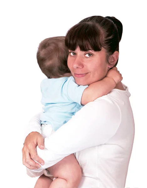 Máma objímá dítě. Šťastná mladá matka líbání dítě na bílém pozadí — Stock fotografie