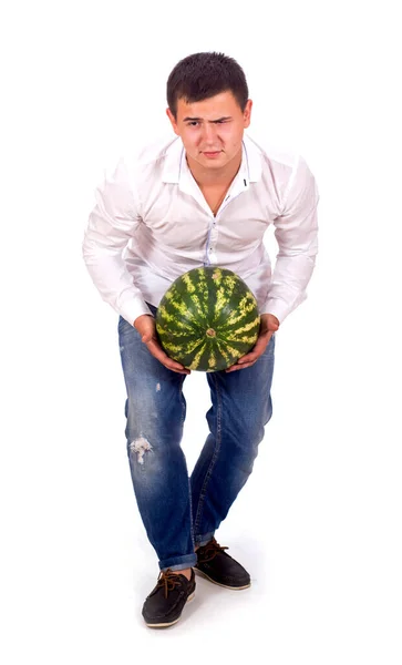Man i vit skjorta och jeans drar stor vattenmelon isolerad på vit bakgrund — Stockfoto