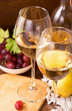 Şarap ve üzümler ahşap masaya dizilmiş.