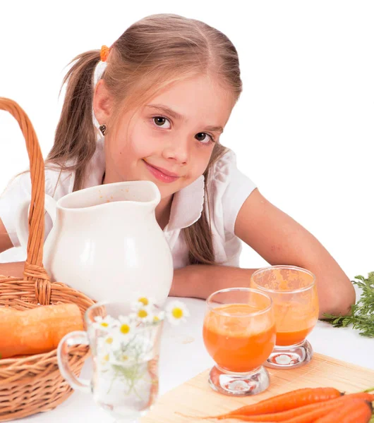 Μικρό χαριτωμένο κορίτσι ποτό χυμό καρότο. λευκό φόντο — Φωτογραφία Αρχείου