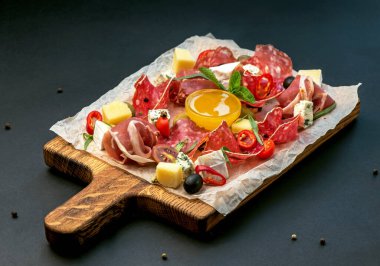 Pirzola - jambon, jambon, siyah arka planda tahta üzerinde salam