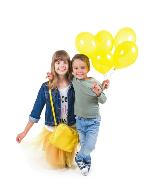 Porträtt av vacker flicka och pojke med gula ballonger — Stockfoto