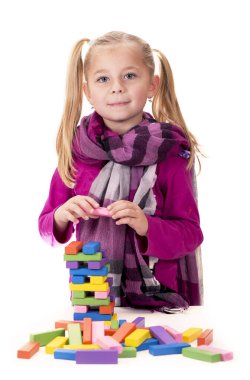 beyaz arka plan üzerinde ahşap oyunu jenga ile oynayan küçük kız