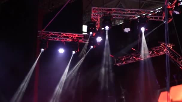 Iluminación del escenario en un concierto. muchos focos que iluminan el escenario en un concierto con niebla — Vídeos de Stock