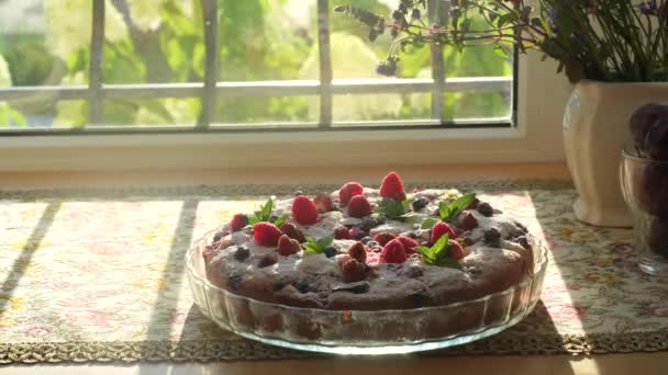Женщина положила торт с малиной, мятой и ягодами на подоконник в уютном частном доме. — стоковое видео