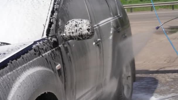Lavar um carro com pressão de água numa estação de autoatendimento. — Vídeo de Stock