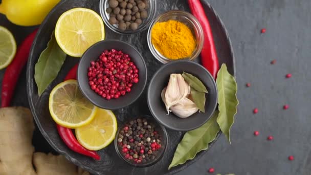 Kleurrijke achtergrond van verschillende kruiden en specerijen voor het koken in kommen. Bovenaanzicht — Stockvideo