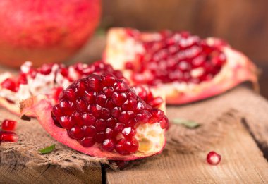 Sulu nar ve yapraklarla sulu nar, eski ahşap masa üzerinde güzel bir kompozisyon.