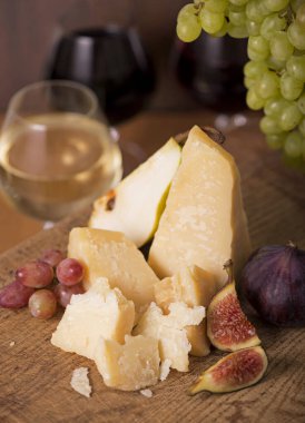Üzüm, kavun, incir, kraker, bal, fındık ve beyaz şarapla servis edilen peynir tabağı.
