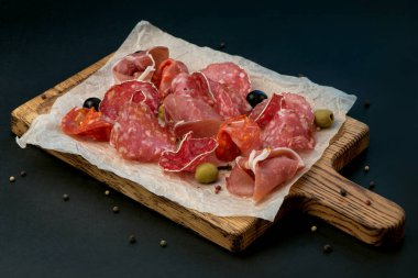 Pirzola - jambon, jambon, siyah arka planda tahta üzerinde salam