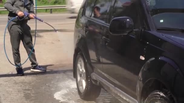 Handwas met drukwater in een wasstraat buiten. Een persoon wast zijn auto alleen — Stockvideo