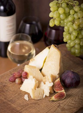Üzüm, kavun, incir, kraker, bal, fındık ve beyaz şarapla servis edilen peynir tabağı.