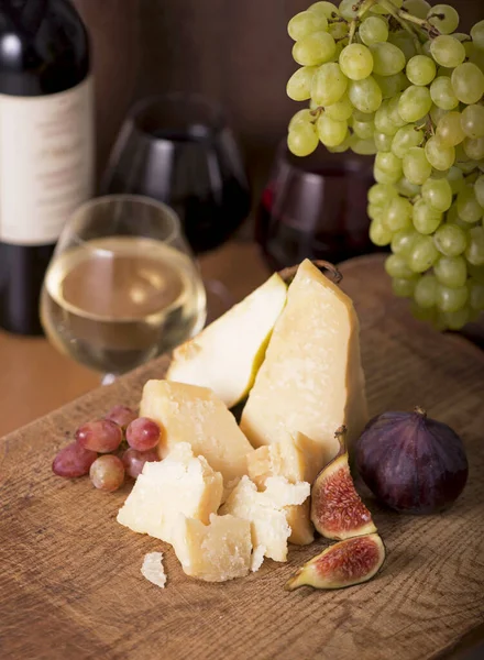 Üzüm, kavun, incir, kraker, bal, fındık ve beyaz şarapla servis edilen peynir tabağı.