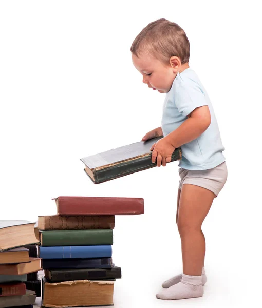 Chico se para cerca de una pila de libros para un retrato educativo - aislado sobre fondo blanco — Foto de Stock