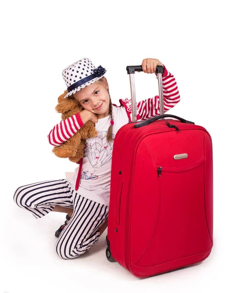รูปภาพของเด็กผู้หญิงตัวเล็กที่มีกระเป๋าเดินทางและหมวกแยกจากสีขาว — ภาพถ่ายสต็อก