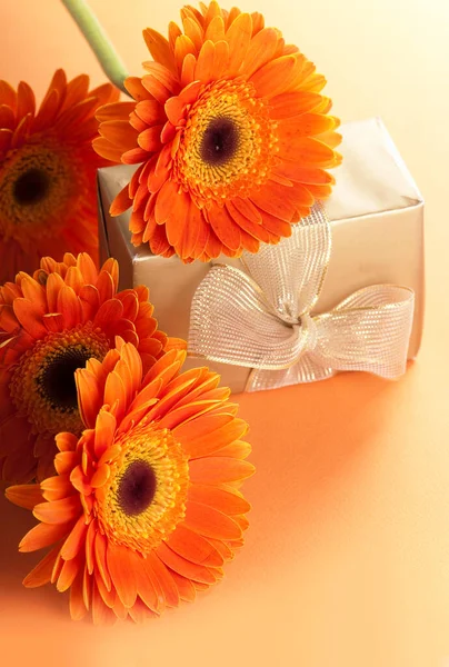 Πορτοκαλί Λουλούδια Και Δώρο Χρυσή Συσκευασία — Φωτογραφία Αρχείου