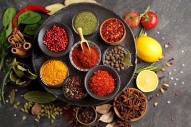 Değişik baharatlar, taş masada kaliteli kaşıklar. Renkli Bitki ve Baharatlar Doğu pazarı.