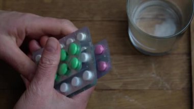 Şişeden hap dökülen kadın eli, beyaz ilaç tutan kadın eli.