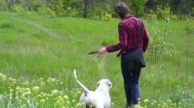 A man throws a stick at his dog in the park