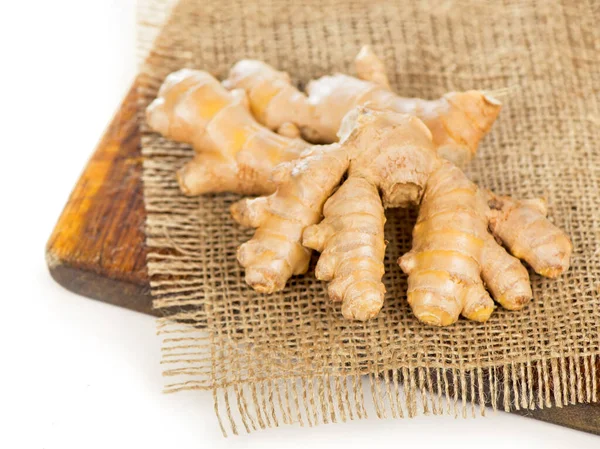 Whole ginger roots on dark wooden background