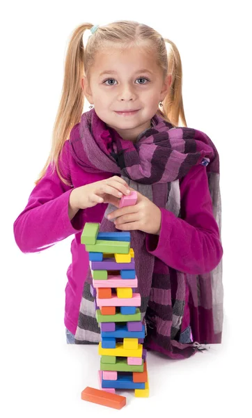 白い背景に木製のゲームジェンガで遊ぶ小さな女の子 — ストック写真