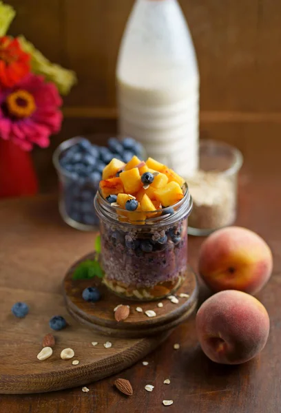 Homemade Greek yogurt with granola, mint, blueberries and strawberry in a glass jar on white background, Health food from yogurt concept