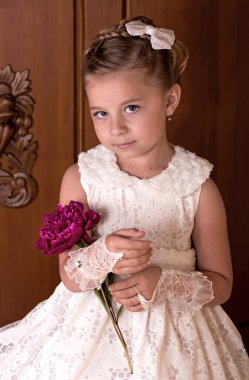 Girl holding peonies bouquet on wooden background
