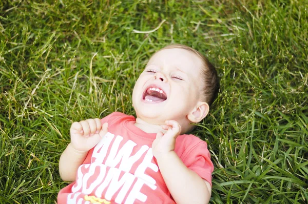 Pequeno menino chorando na grama — Fotografia de Stock