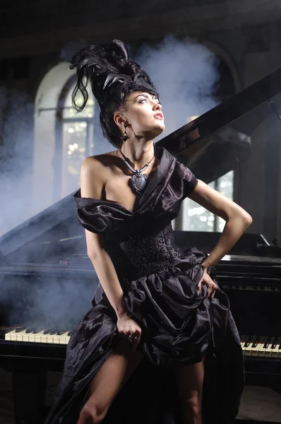 Senhora elegante com penteado luxuoso perto de piano — Fotografia de Stock
