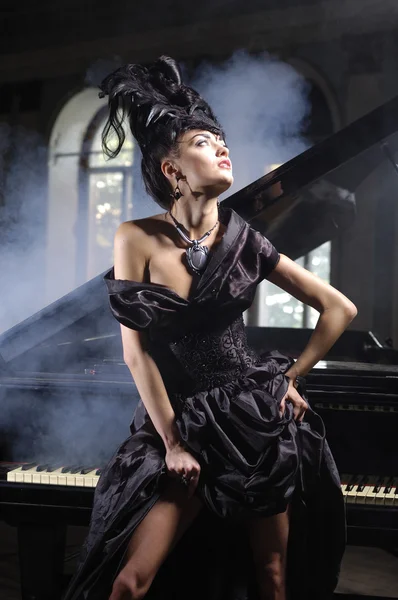 Elegant lady with luxurious hairstyle near piano — Stock Photo, Image