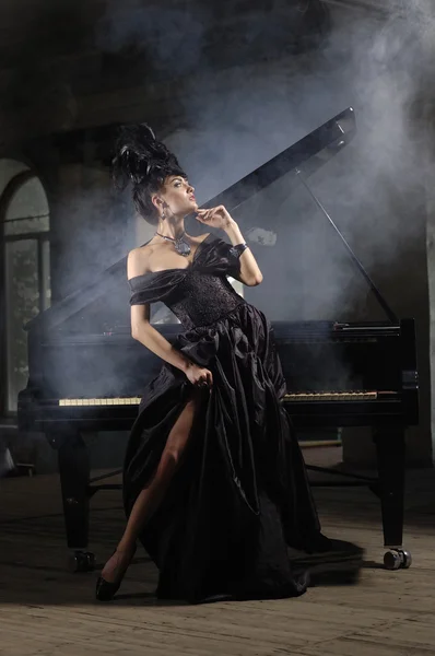 Elegante signora con acconciatura di lusso vicino al pianoforte — Foto Stock