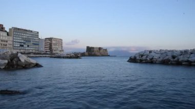 Napoli 'de kışın denizde gün batımında Castel Dell' ovo