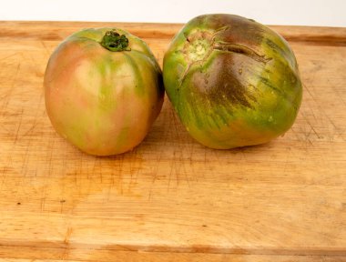 Tahta kesme tahtasındaki kırmızı Sorrento ve bazik domatesler