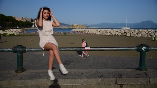 Κομψά Ντυμένη Έφηβη Κοπέλα Χαλαρώνει Στον Παραλιακό Πεζόδρομο — Αρχείο Βίντεο