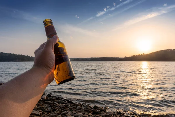 Pria Bersulang Tepi Sungai Dengan Matahari Terbenam Minuman Emas Stok Foto Bebas Royalti