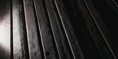 Çatlak boyalı ahşap platform, karanlıkta tahtalardan yapılmış.