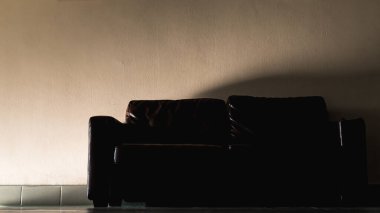 Bir ofis binasının koridorundaki koyu renkli deri koltuğun renkli görüntüsü.