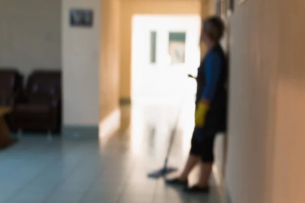 在清理走廊和办公室的过程中 一名妇女清扫房舍的模糊形象 免版税图库图片
