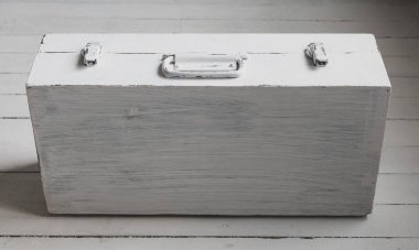 Beyaza boyanmış eski bir bavul.