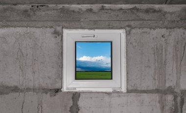 Evin karanlık bodrumunda sokağa bakan küçük plastik bir pencere.