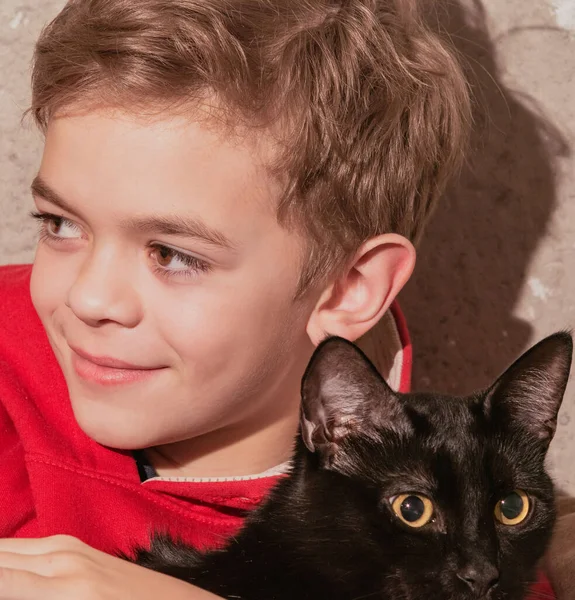 猫を手にした赤いTシャツの少年の肖像画 — ストック写真