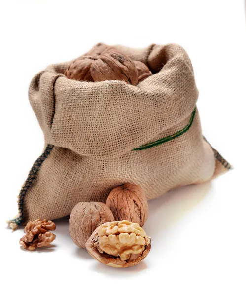 Valnötter och en väska på vit — Stockfoto