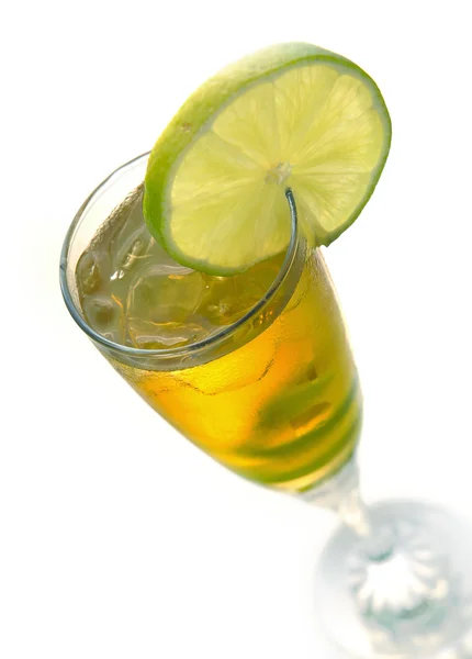 Yellow cocktail in glass with lime — Stock Photo, Image