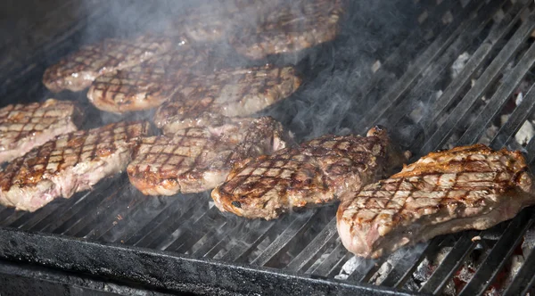 Beef steak cooking on an open flame grill — Stock Photo, Image